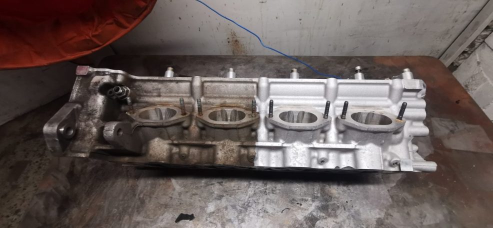 Motorblock mit mehreren Zylinderköpfen, teilweise verschmutzt und abgenutzt.